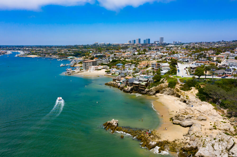 The Best Places for Sailing in the US: 8 Amazing Holiday Destinations 2 This is a pretty picture of Newport, Rhode Island with the great skyline in the background and the lovely sandy, but rocky beach in the front