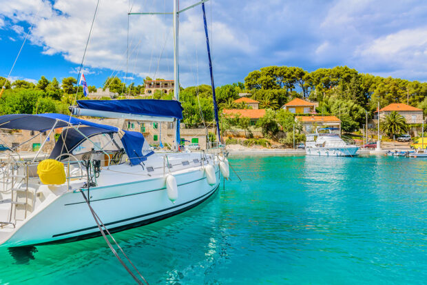 Eines der Top-Reiseziele im Herbst ist Kroatien, besonders Dubrovnik. Hier zu sehen ist ein Segelboot, das direkt vor der Küste der Stadt ankert